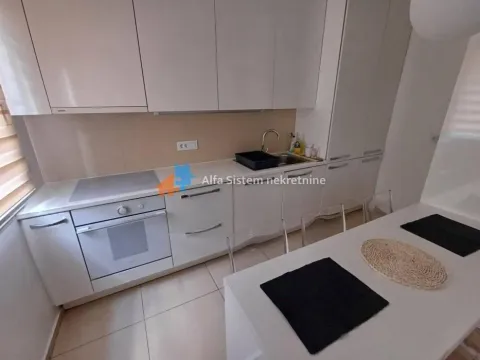Moderna bela kuhinja sa ugrađenim aparatima i trpezarijskim stolom. - image 8