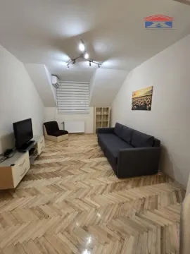 Dnevna soba sa garniturom, televizorom i drvenim podom u potkrovlju. - image 3