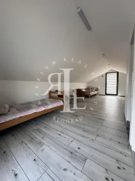 Attic furnished as a bedroom with beds and wooden flooring. - image 33