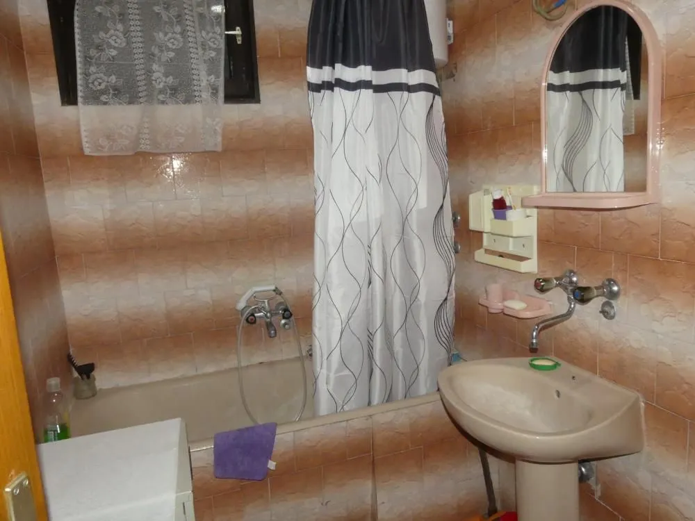Bathroom equipped with a bathtub, washbasin, and mirror.
