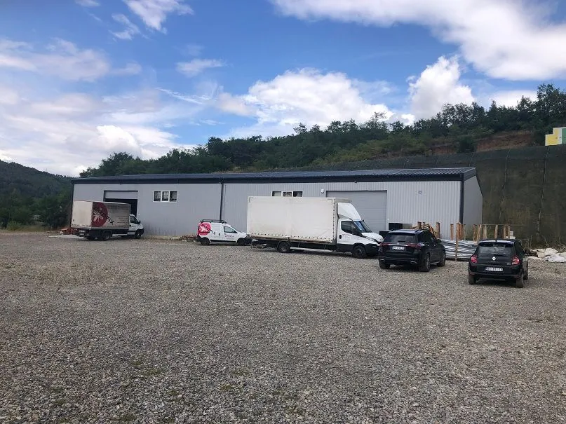 Exterior view of a commercial building with warehouse space and a parking lot in the yard.