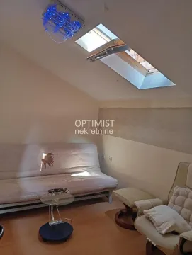 Attic living room with a skylight and seating furniture. - image 6