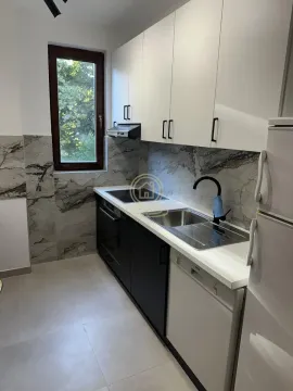 Modern kitchen with white and dark cabinets and a window. - image 17
