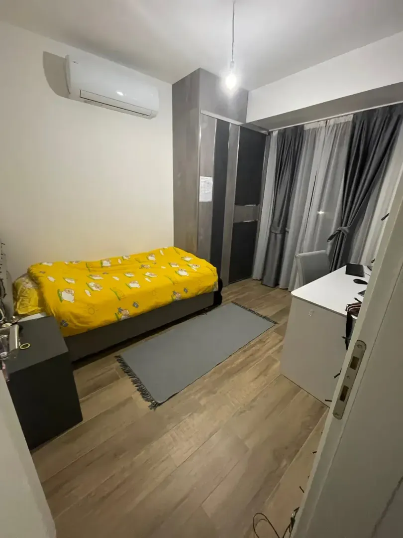 Small bedroom with a bed, desk, wardrobe, and air conditioning unit.