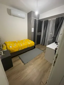Small bedroom with a bed, desk, wardrobe, and air conditioning unit. - image 11