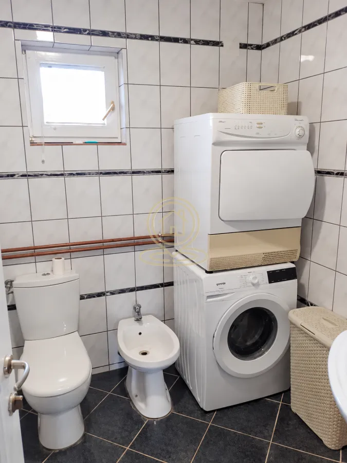 Kupatilo opremljeno toaletom, bideom i mašinama za pranje i sušenje veša.