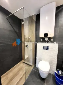 Savremeno opremljeno kupatilo sa tuš kabinom i ugradnom wc šoljom. - image 16