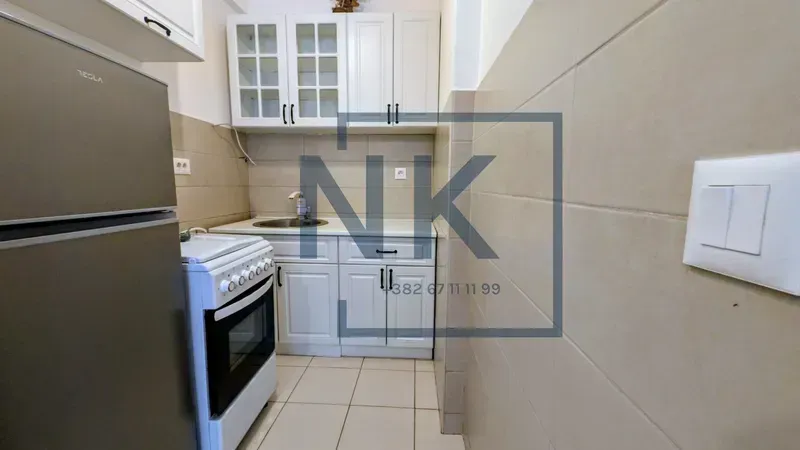 Smaller kitchen with white cabinets, a stove, and a refrigerator.
