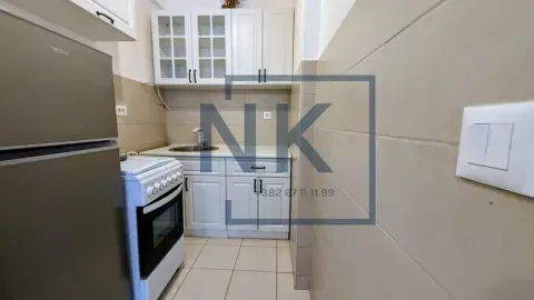 Smaller kitchen with white cabinets, a stove, and a refrigerator. - image 7