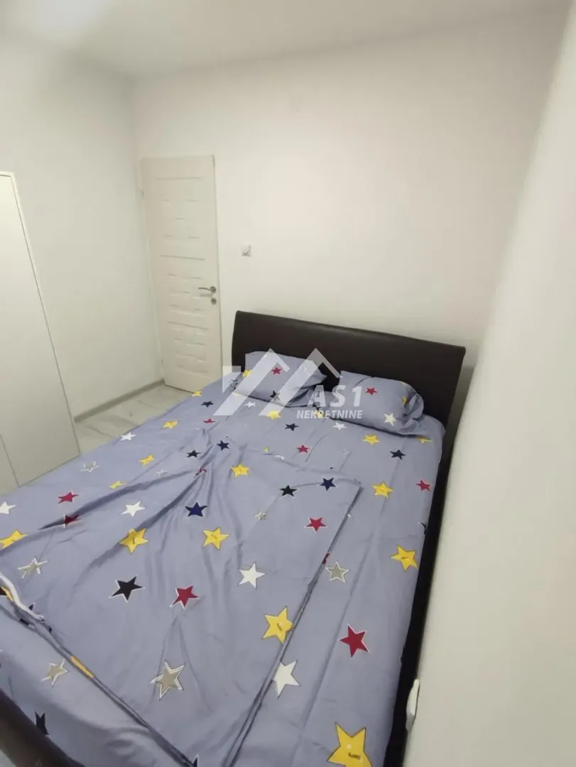 Spavaća soba sa bračnim krevetom i posteljinom sa motivom zvezda.