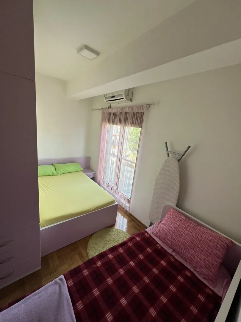 Bright bedroom featuring two beds and a wardrobe.