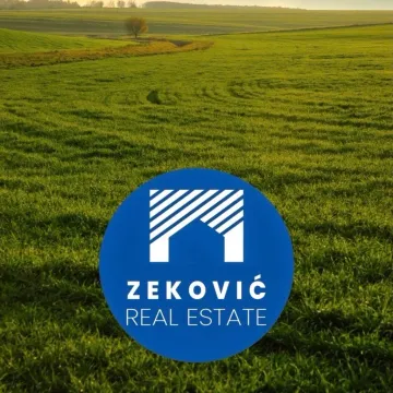 Pogled na prostranu zelenu livadu sa logotipom agencije u prvom planu. - image 4