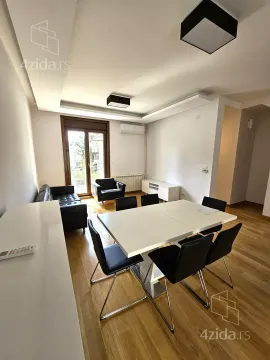 Living room with a dining table and chairs, a black sofa set, and access to the terrace. - image 15