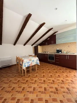 Kuhinja sa trpezarijom i drvenim gredama na plafonu u potkrovlju. - image 9