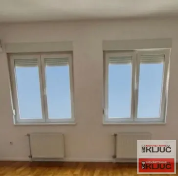 Prazna soba sa dva prozora i radijatorima. - image 3