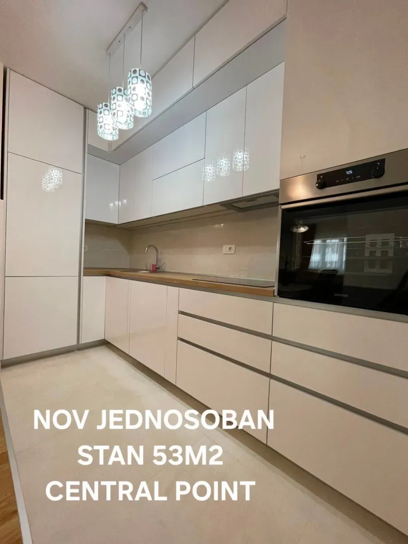 Moderna bijela kuhinja sa ugrađenom rernom.