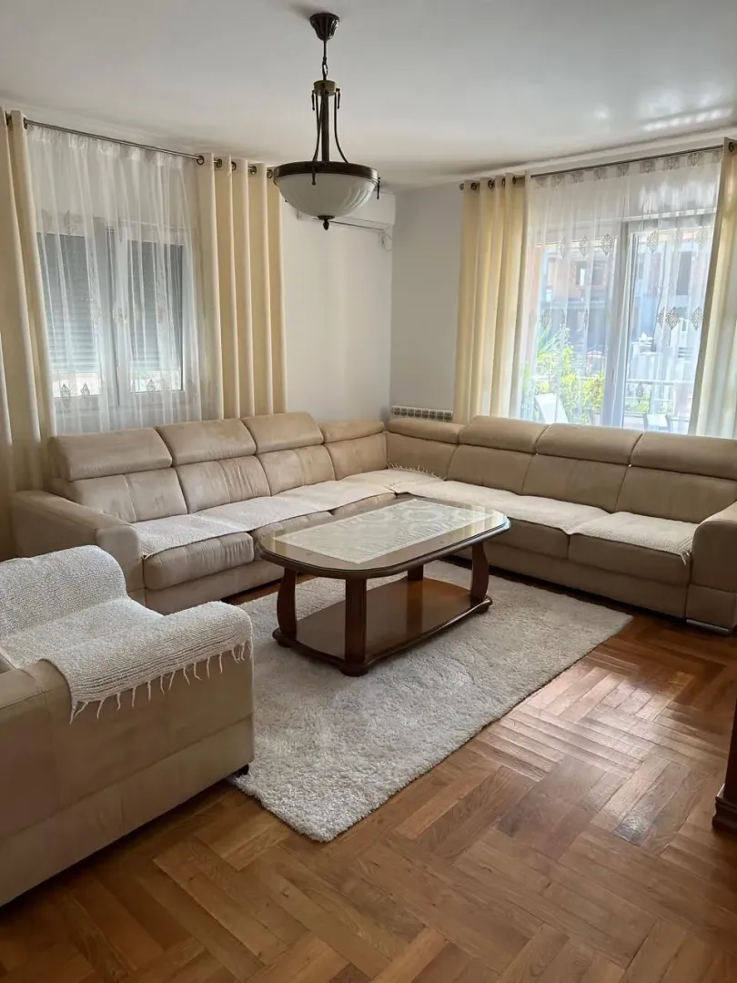 Spacious living room with a sectional sofa and parquet flooring.