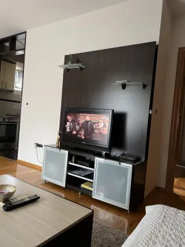 Living room with a TV stand and a coffee table. - image 4
