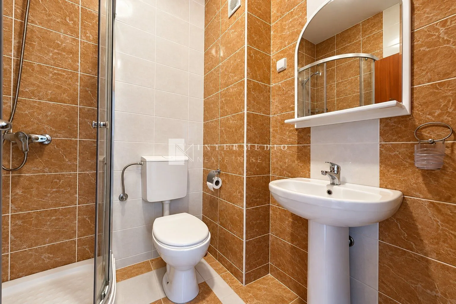 Kompaktno kupatilo sa tuš kabinom, umivaonikom i WC šoljom.