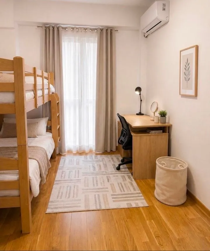 Furnished children's bedroom with a bunk bed, desk, and window.