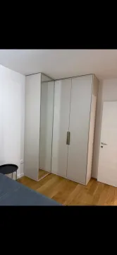 Spavaća soba sa velikim ugradnim plakarom i drvenim podom. - image 5
