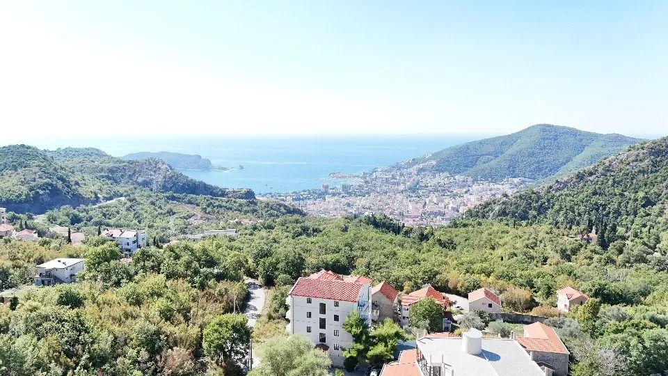 Bird's-eye view of the city, sea, and surrounding hills.