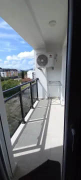 Bright balcony with an air conditioning unit and surrounding view. - image 7