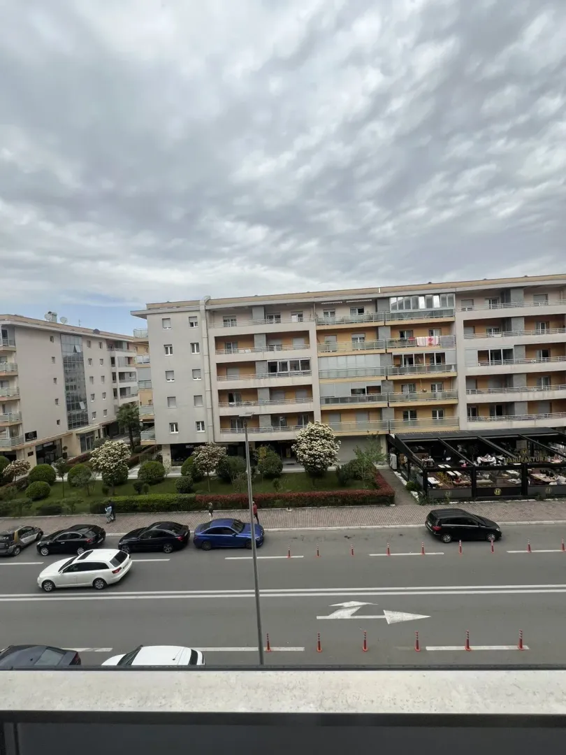 Pogled sa balkona na susjednu stambenu zgradu i ulicu.