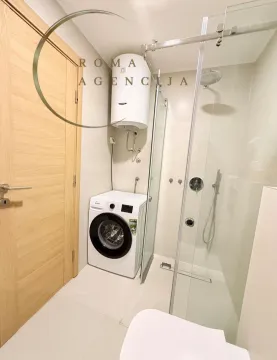 Modernly equipped bathroom with a shower cabin and washing machine. - image 9
