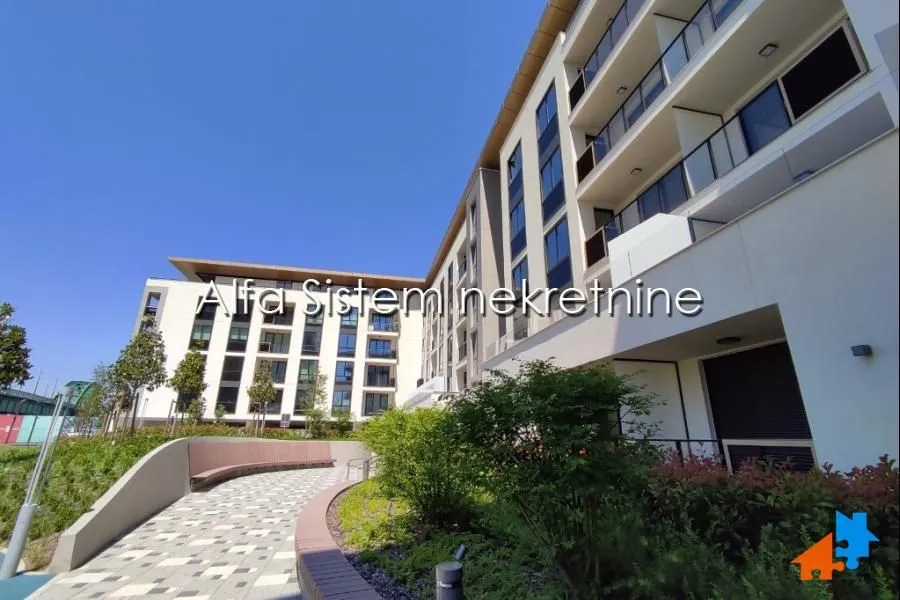 View of the exterior of a modern residential building with a landscaped courtyard.