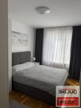 Spavaća soba sa bračnim krevetom i prozorom prekrivenim zavesama. - image 5