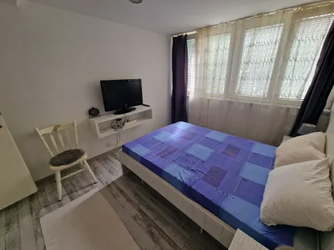 Bedroom with a double bed, window, and wall-mounted TV. - image 9