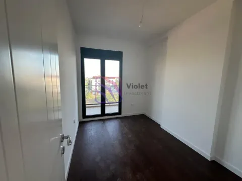 Empty room with dark parquet flooring and balcony doors. - image 8