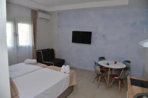Bedroom with two beds, a dining table, and an air conditioning unit. - image 8