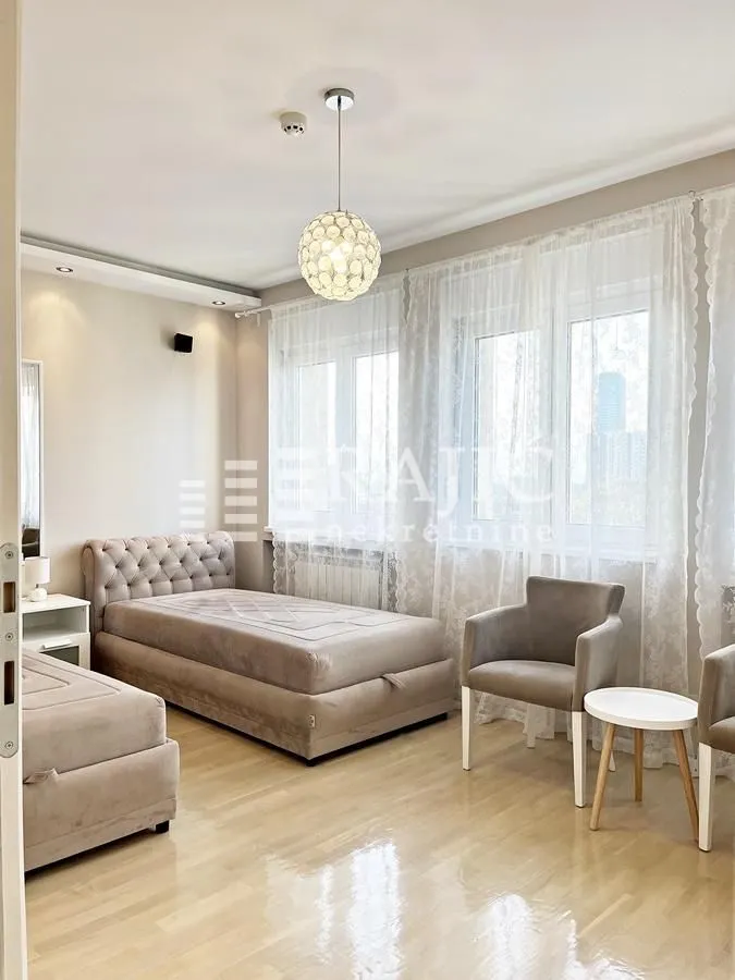 Furnished bedroom with a bed and armchairs.