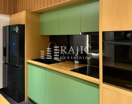 Modern kitchen with green fronts and wooden elements. - image 5