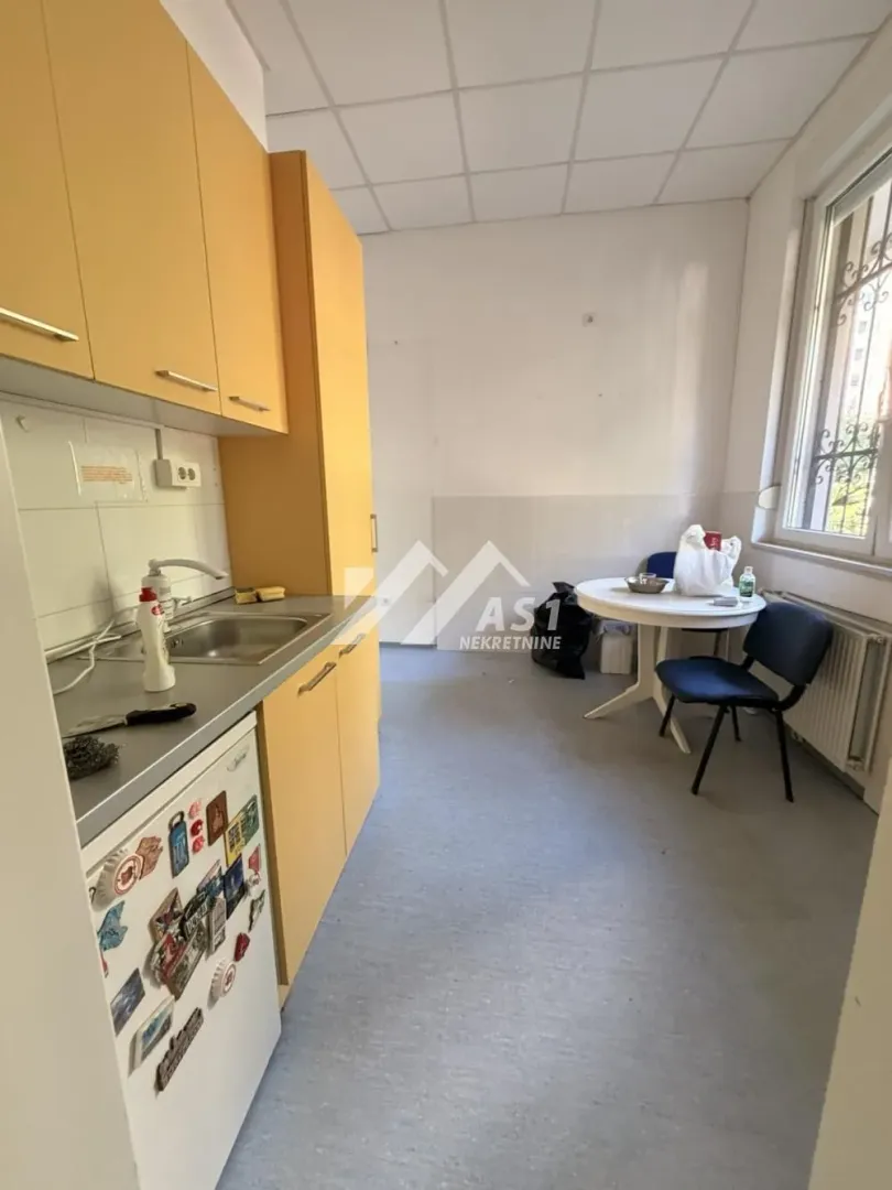 Smaller kitchen with yellow cabinets and a dining table by the window.