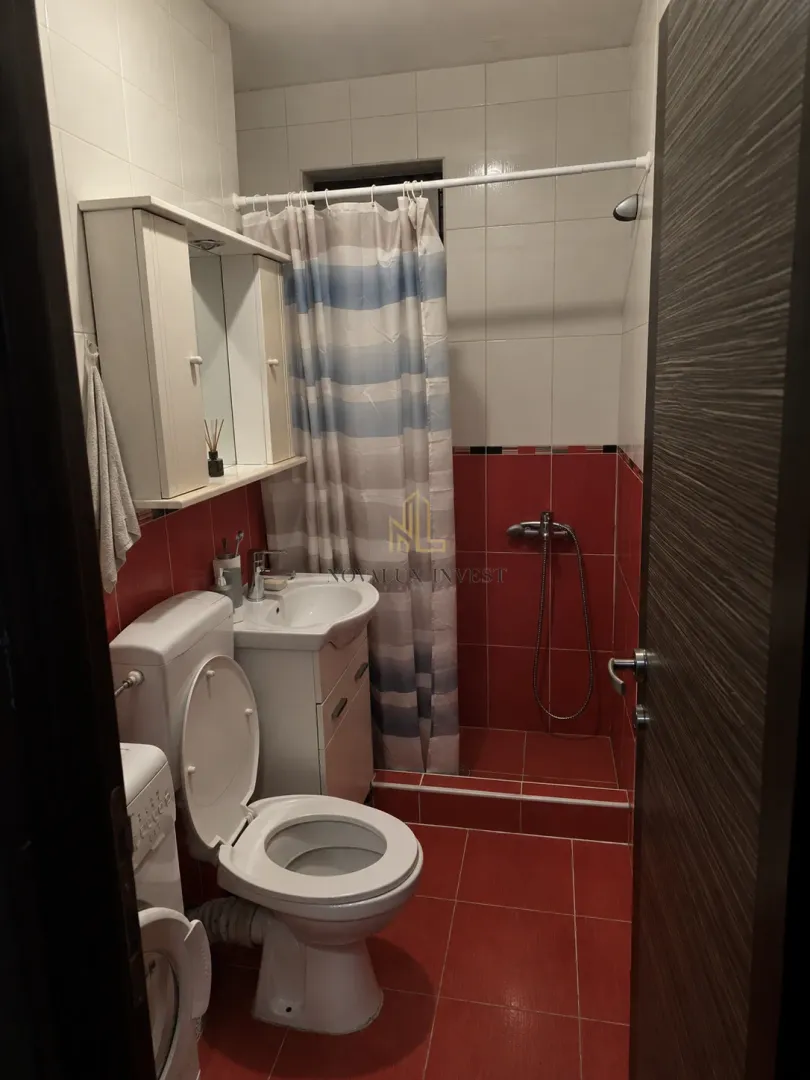 Bathroom with a toilet, washbasin, and a shower with a curtain.
