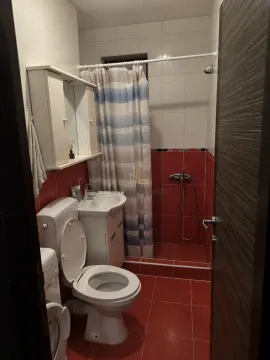 Bathroom with a toilet, washbasin, and a shower with a curtain. - image 4