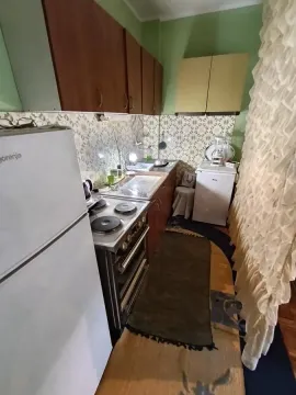 Manja kuhinja sa drvenim elementima, šporetom i frižiderom. - image 15