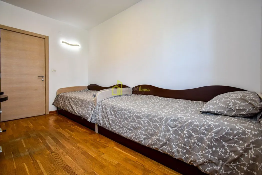 Bedroom with two beds and wooden flooring.