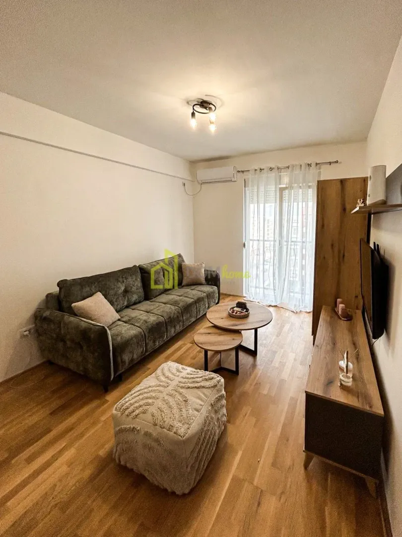 Living room with a sofa, coffee tables, and wooden furniture.