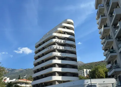 Exterior of a modern multi-family residential building with terraces and mountain scenery in the background. - image 9