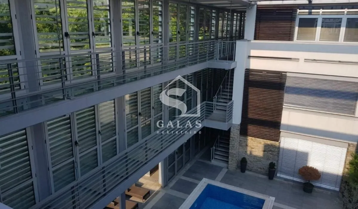 Exterior of a modern building with a swimming pool and a glass facade.