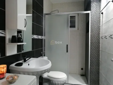 Bathroom equipped with a washbasin, toilet, and a shower cabin with sliding doors. - image 12