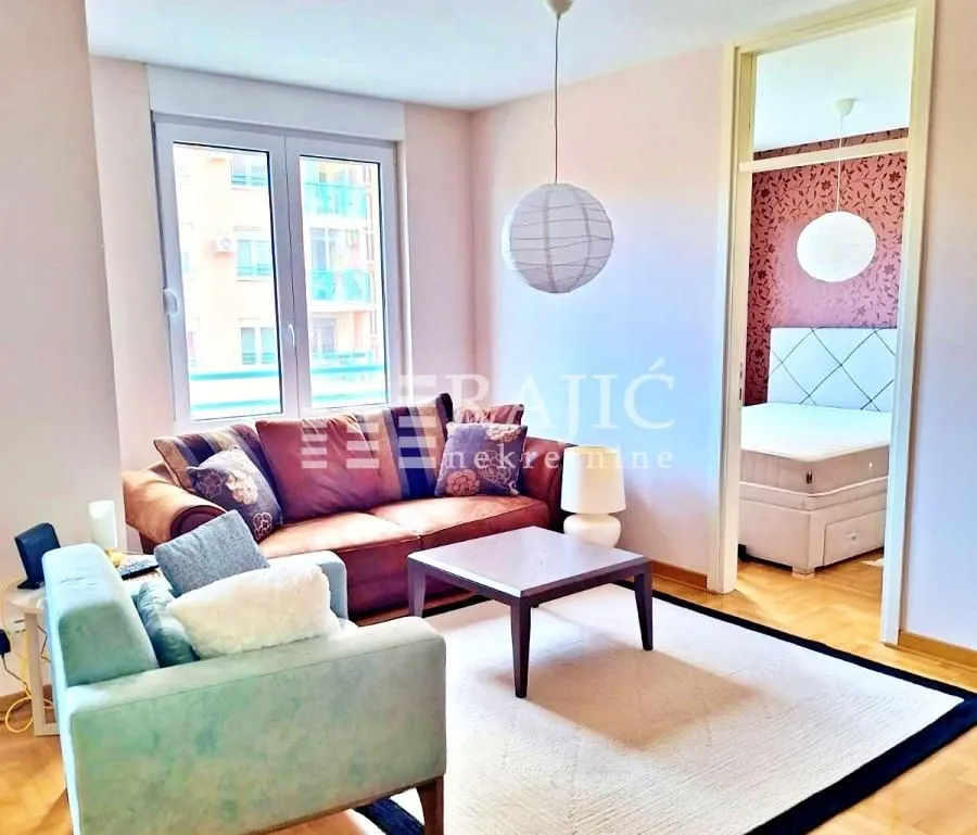 Furnished living room with a sofa set and a view into the adjacent bedroom.