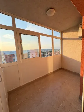 Zastakljeni balkon sa pločicama na podu i pogledom na grad. - image 13