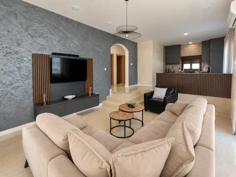 Living room connected to the kitchen, furnished with a modern corner sofa and TV unit. - image 7