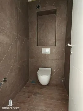 Manje kupatilo obloženo keramičkim pločicama u braon tonovima sa ugradnom šoljom. - image 7