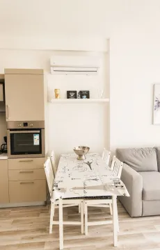 Modern kitchen with a dining table and a grey sectional sofa. - image 5